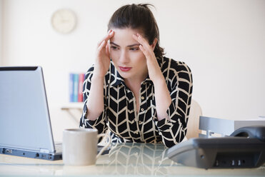 Kaukasische Geschäftsfrau mit Kopfschmerzen am Laptop - BLEF05078