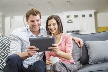 Kaukasisches Paar benutzt digitales Tablet auf dem Sofa - BLEF05089