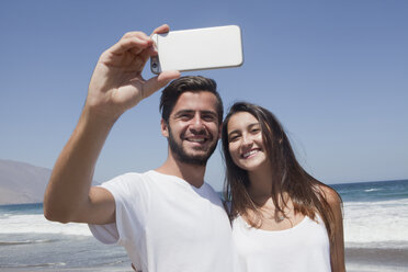 Hispanisches Paar posiert für Handy-Selfie am Strand - BLEF05097