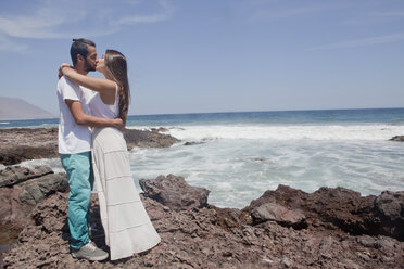 Hispanisches Paar küsst sich am felsigen Strand - BLEF05100