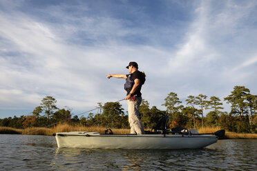 Caucasian man fly fishing in kayak on river - BLEF05104