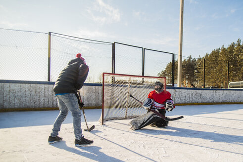 Kaukasische Jungen spielen Eishockey im Freien - BLEF05118