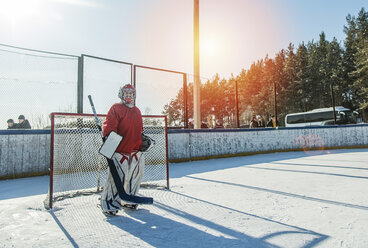 Kaukasischer Junge spielt Torwart beim Eishockey im Freien - BLEF05119