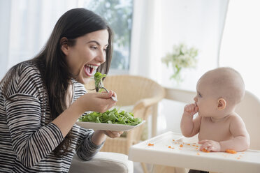 Kaukasische Frau isst Salat und beobachtet ihre kleine Tochter - BLEF05134