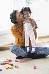 Lächelnde schwarze Mutter küsst ihre kleine Tochter - BLEF05150