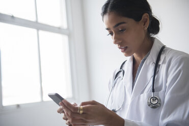 Indischer Arzt schreibt eine SMS mit seinem Handy - BLEF05200