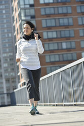 Hispanic woman running in city - BLEF05223