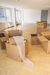 Cardboard boxes and bubble wrap in empty apartment - BLEF05238