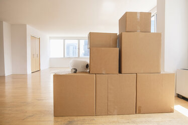 Cardboard boxes and bubble wrap in empty apartment - BLEF05244