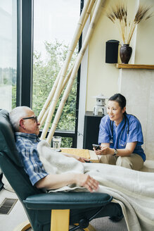 Krankenschwester schreibt in der Nähe eines Patienten eine SMS mit dem Handy - BLEF05299