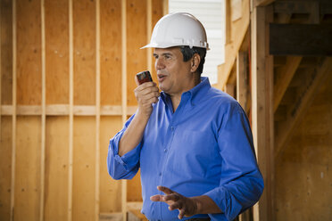 Native American construction worker talking on cell phone - BLEF05303