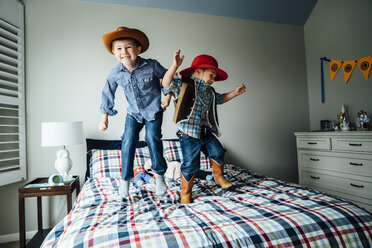 Kaukasische Jungen in Cowboy-Kostümen springen auf dem Bett - BLEF05333