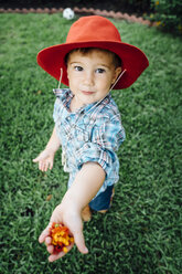 Kaukasischer Junge mit Cowboyhut und Blumen in der Hand - BLEF05338