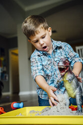 Kaukasischer Junge spielt mit Spielzeugdinosaurier - BLEF05340