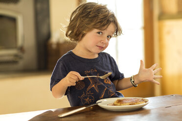 Caucasian boy gesturing while eating pancakes - BLEF05359