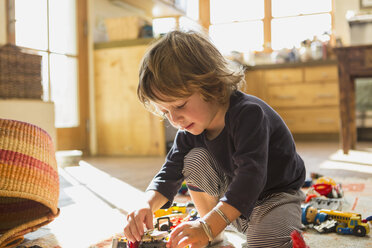 Caucasian boy playing with toys on floor - BLEF05364