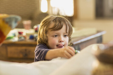 Caucasian boy with tongue out playing with toy - BLEF05365