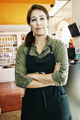 Serious Mixed Race hairdresser posing in hair salon - BLEF05394