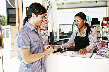 Customer paying in hair salon with cell phone - BLEF05397