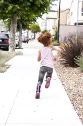 Rear view of girl running on city sidewalk - BLEF05424