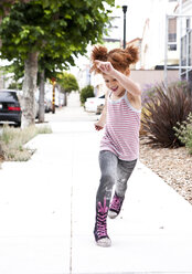 Smiling girl running on city sidewalk - BLEF05426