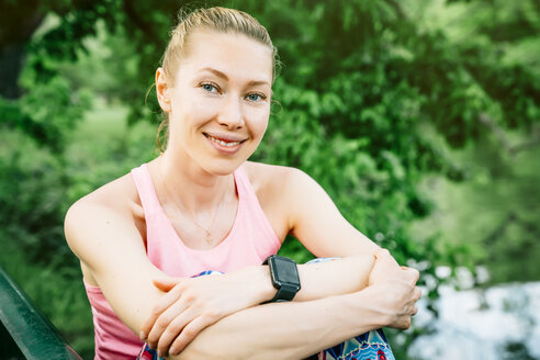 Kaukasische Frau mit intelligenter Uhr, die im Freien sitzt - BLEF05450