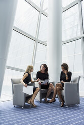 In Sesseln sitzende Geschäftsfrauen im Gespräch - BLEF05476