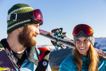 Paar trägt Skier auf verschneitem Berg - BLEF05484