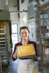 Kaukasische Frau zeigt Kuchen in einer Bäckerei - BLEF05549
