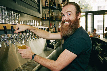 Smiling Caucasian bartender pouring beer - BLEF05563