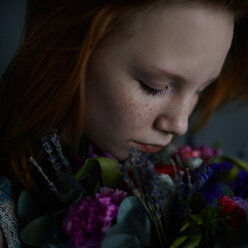 Kaukasisches Teenager-Mädchen riecht an Blumen - BLEF05569