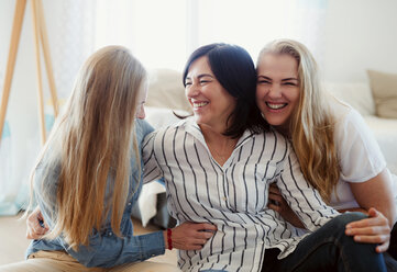 Visiting daughters embracing their mother - HAPF02883