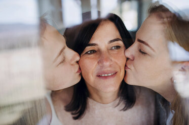 Visiting daughters kissing their mother, standing at the window - HAPF02891