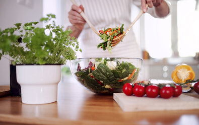 Ältere Frau bereitet Salat in ihrer Küche zu - HAPF02906