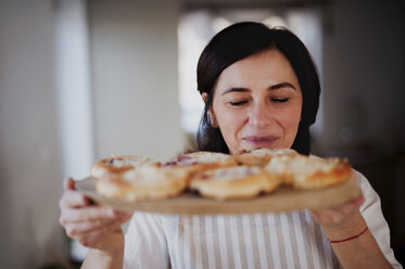 Ältere Frau serviert hausgemachten Kuchen auf einem Holztablett - HAPF02911