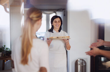 Mother serving her daughters homemade cake - HAPF02913