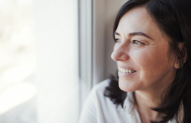 Reife Frau schaut aus dem Fenster - HAPF02933