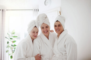 Porträt einer glücklichen reifen Frau mit zwei Töchtern in einem Badezimmer zu Hause - HAPF02948
