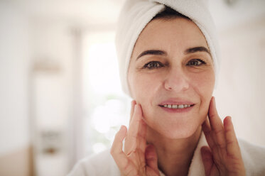 Portrait of smiling mature woman in a bathroom at home - HAPF02953