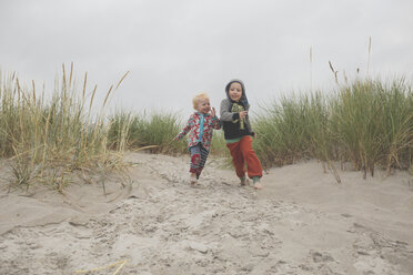 Junge und Mädchen laufen gemeinsam zum Strand - IHF00040