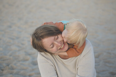 Kleines Mädchen, das seine Mutter am Strand umarmt - IHF00043