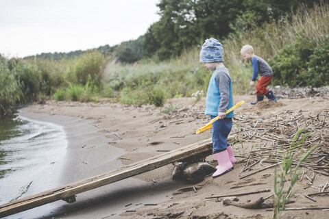 Junge und Mädchen spielen an einem wilden Sandstrand, lizenzfreies Stockfoto