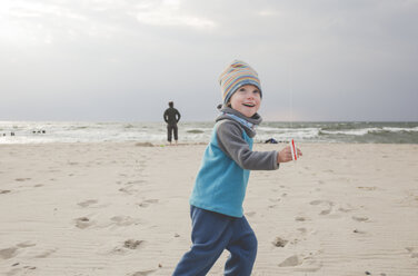 Glückliches kleines Mädchen spielt mit Drachen am Strand - IHF00048