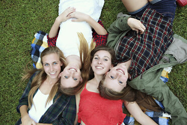 Smiling women laying on blanket in grass - BLEF05605