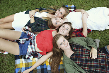 Lächelnde Frauen liegen auf einer Decke im Gras - BLEF05606