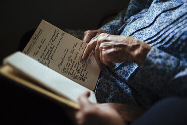 Older woman reading handwriting to granddaughter - BLEF05635