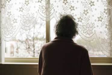Pensive mixed race older woman looking out window - BLEF05671