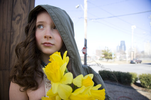 Close up of Caucasian girl holding flowers outdoors - BLEF05704