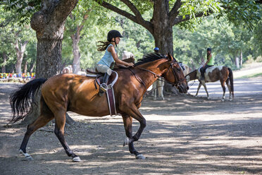 Reiterin reitet Pferd auf Ranch - BLEF05710