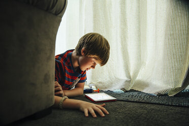 Caucasian boy using digital tablet in blanket fort - BLEF05731